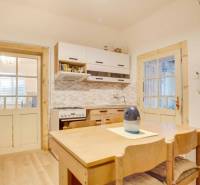 Kuchyně v rodinném domě s dřevěným nábytkem a podlahou s dřevěným dekorem.