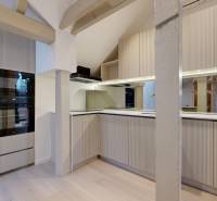 Kuchyně ve 4pokojovém bytě s varnou deskou, troubou a podlahou s dřevěným dekorem.