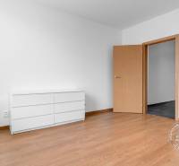 Pokoj se světlým nábytkem a podlahou s dřevěným dekorem v 3-pokojovém bytě.