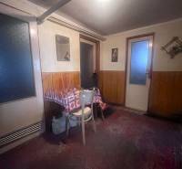 Interiér rodinného domu s dřevěným obložením, stolem a židlí.