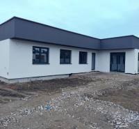 Rodinný dům v Žihárci s plochou střechou a světlou fasádou.