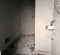 Interiér rodinného domu během renovace s viditelnými rozvody a nehotovými stěnami.