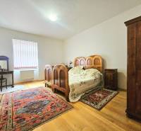 Ložnice v 3-pokojovém bytě s dřevěným dekorem a vintage nábytkem.