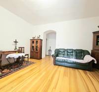 Obývací pokoj v 3pokojovém bytě s podlahou s dřevěným dekorem a dřevěným nábytkem.