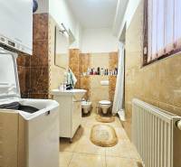 3pokojový byt s koupelnou, pračkou, vanou a oknem, dekorativní obklady na stěnách.