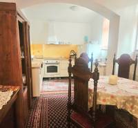 Kuchyně v 3-pokojovém bytě s dřevěným nábytkem a vintage kobercem.