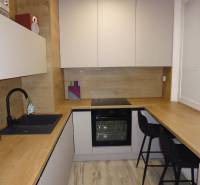 Kuchyně s podlahou s dřevěným dekorem v 2pokojovém bytě, vybavená pohodlným sezením.