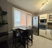 Kuchyně v 3-pokojovém bytě s moderní linkou a jídelním stolem.