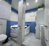 Koupelna s toaletou a vířivkou ve 3-pokojovém bytě, dominují modré kachličky.