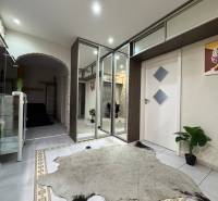 Interiér 3-pokojového bytu s dlažbou, zrcadlovou skříní a dekorativními rostlinami.