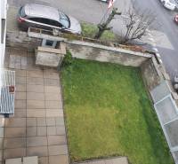 Pohled shora na zahradu a terasu rodinného domu s parkováním na ulici Súľovská.