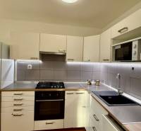 Kuchyně v 3-pokojovém bytě s bílými skříňkami a vestavěným spotřebičem.