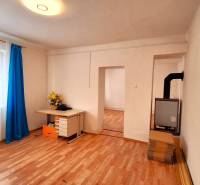 Rodinný dům s podlahou s dřevěným dekorem, okno se záclonami a psací stůl.