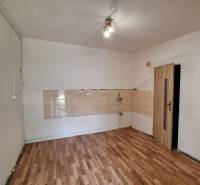 Prázdná místnost v rodinném domě s dlaždicemi a podlahou s dřevěným dekorem.