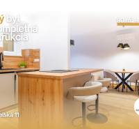 Interiér 3-pokojového bytu s kuchyňskou linkou a podlahou s dřevěným dekorem.