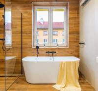 Koupelna s vanou, podlahou s dřevěným dekorem v 3-pokojovém bytě.