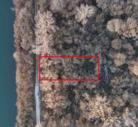 Letecký pohled na rekreační pozemky v Nové Vsi nad Váhem, obklopené lesem a řekou.