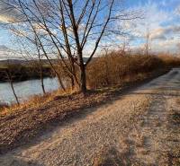 Rekreační pozemky v Nová Ves nad Váhom s přírodní cestou a řekou na podzim.