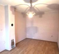 Pokoj v rodinném domě s podlahou s dřevěným dekorem a závěsným svítidlem.