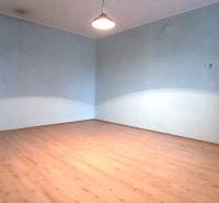 Pokoj v rodinném domě s podlahou s dřevěným dekorem a modrými stěnami.