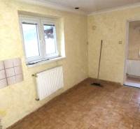 Místnost v rodinném domě s kachličkami na stěně a dlažbou na podlaze.