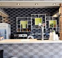 Barový pult s nápoji a pivními kohoutky v obchodních prostorách.