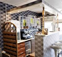 Interiér obchodních prostor s barovým pultem, dekorativními stěnami a barovými židlemi.