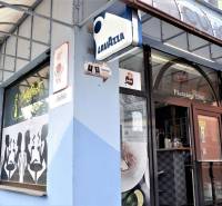 Exteriér obchodních prostor v Šali s kavárenskými motivy na výloze.