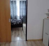 Interiér s podlahou s dřevěným dekorem, posuvnými dveřmi a černobílými závěsy v 3-pokojovém bytě.