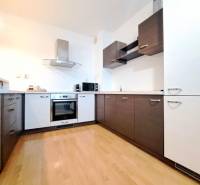 Kuchyně s podlahou s dřevěným dekorem ve 2pokojovém bytě.