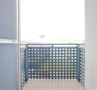 Balkon v Galantě z 2-pokojového bytu se zábradlím a dlažbou, výhled na město.