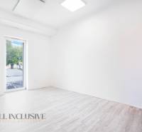 Prázdná kancelář s podlahou s dřevěným dekorem a velkým oknem.