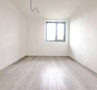 Prázdná místnost s podlahou s dřevěným dekorem a oknem v rodinném domě.