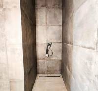 Sprchový kout v rodinném domě s keramickými obklady.