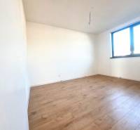 Prázdná místnost s podlahou s dřevěným dekorem a velkým oknem v rodinném domě.