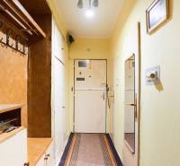 Chodba v 3-pokojovém bytě s věšákem, zrcadlem a jednoduchým osvětlením.