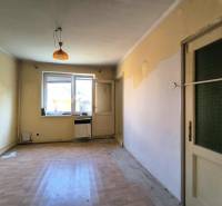 Pokoj v rodinném domě s oknem, dveřmi a podlahou.