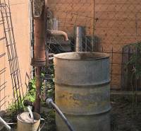 Vodní pumpa s kovovým sudem na zahradě rodinného domu v Partizánskem.