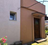 Rodinný dům v Partizánském s barevnou omítkou a zahradou.