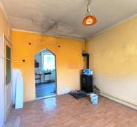 Pokoj v rodinném domě s kamny s dveřmi do kuchyně.