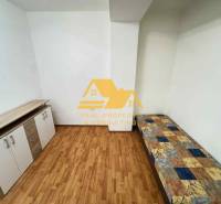 Pokoj v 3-pokojovém bytě s postelí, komodou a podlahou s dřevěným dekorem.