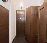 Chodba 2pokojového bytu s tmavými dveřmi a úložnými skříněmi.