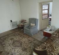 Pokoj v rodinném domě s kobercem, křesly a postelí.