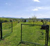 Zahrada v Sabinově s bránou, trávou a květinami pro pozemky - bydlení.