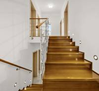 Schodiště s dřevěným dekorem a zábradlím v rodinném domě.