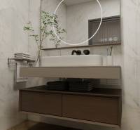 Koupelna ve 3-pokojovém bytě s podlahou s dřevěným dekorem, zrcadlem a umyvadlem.