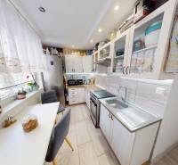 Kuchyně v 2-pokojovém bytě s podlahou s dřevěným dekorem, jasným osvětlením a moderním vybavením.