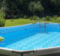 Nafukovací bazén na zahradě chaty, obklopený zelení na Hviezdoslavově ulici v Tisovci.