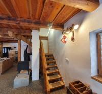 Dřevěné schody v chatě s podlahou s dřevěným dekorem, s vánočními dekoracemi.