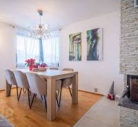 Jídelna v rodinném domě s podlahou s dřevěným dekorem, krbem a nástěnným uměním.